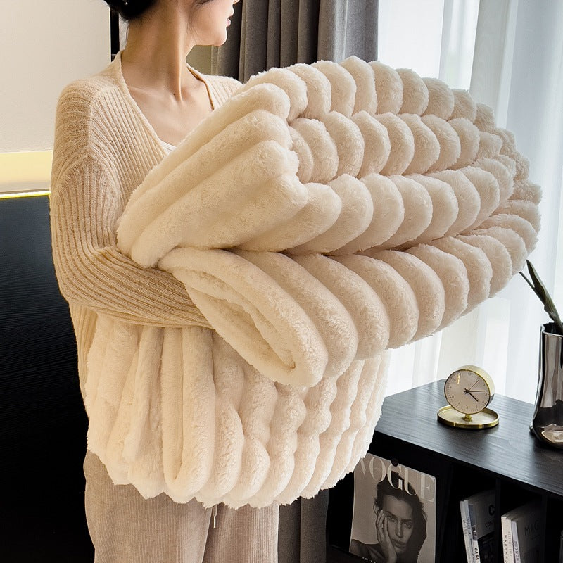 A white cozy warm blanket for winter, held by a woman, showcasing its soft texture and perfect comfort for chilly days.