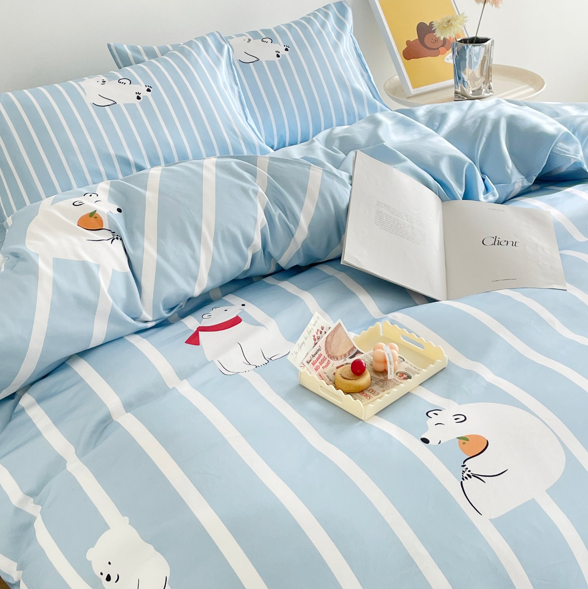 A bright and cheerful bedroom with cute bedding featuring a light blue and white striped design decorated with playful polar bear illustrations.